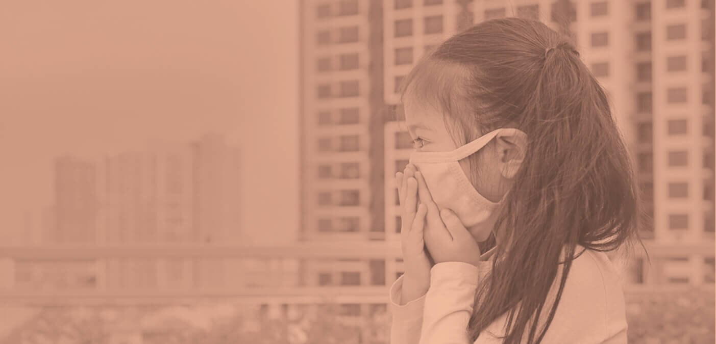 Child with mask looking out over cityscape
